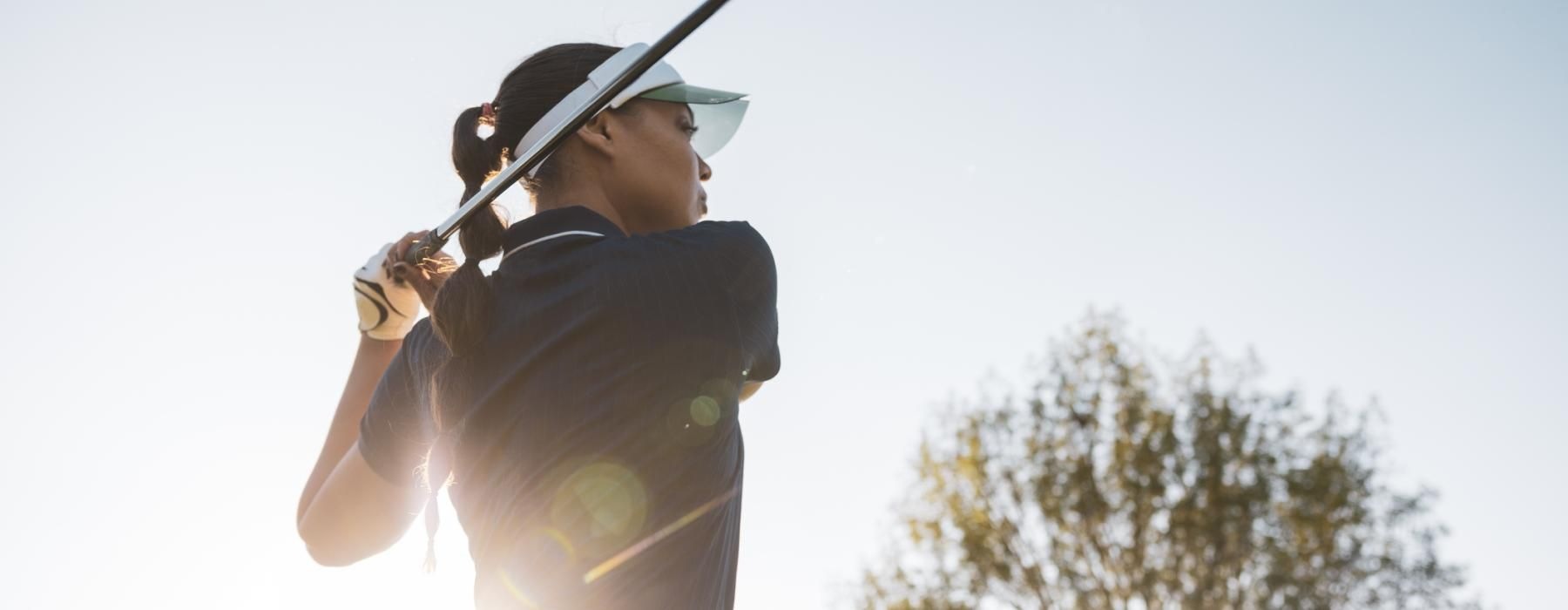 a person swinging a golf club