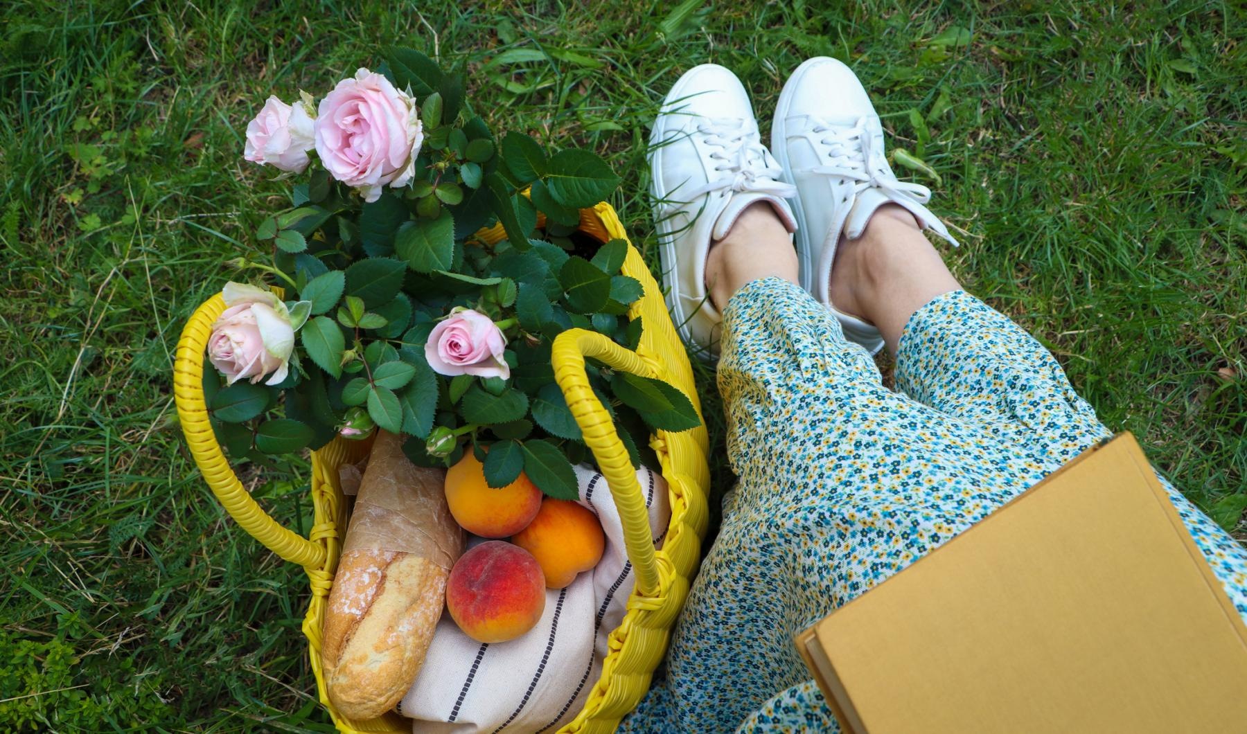 a basket of flowers and a person sitting on grass